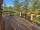 A wood deck with a wooden railing with a view of trees and blue sky at 10178 Hutch Ln, Conifer, CO 80433