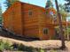 This two-story wooden home sits on a sloped lot, featuring modern windows and a balcony at 10178 Hutch Ln, Conifer, CO 80433