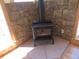 Black stove fireplace with stone surround and wood trim at 10178 Hutch Ln, Conifer, CO 80433