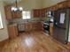 Well-lit kitchen features wooden cabinets, stainless steel appliances, granite counters, and hardwood flooring at 10178 Hutch Ln, Conifer, CO 80433