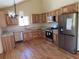 Bright kitchen features stainless steel appliances, wood cabinets, granite counters and hardwood floors at 10178 Hutch Ln, Conifer, CO 80433