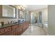 A spacious bathroom featuring dual vanities, decorative mirrors, a walk-in shower, and a soaking tub for relaxation at 924 Brookhurst Ave # C, Highlands Ranch, CO 80129