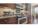 Close-up of stainless steel range with granite countertops and wood cabinetry at 924 Brookhurst Ave # C, Highlands Ranch, CO 80129