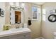 Charming bathroom with a modern vanity, decorative mirror, and natural light from the window at 7641 Lebrun Ct, Lone Tree, CO 80124