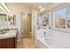 Bright bathroom featuring double sinks, a bathtub, and a separate shower at 7641 Lebrun Ct, Lone Tree, CO 80124