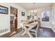 Open dining area with wooden floors, a large mirror, and a view into the kitchen at 7641 Lebrun Ct, Lone Tree, CO 80124