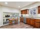 Cozy kitchen with stainless appliances, wooden cabinetry, and adjacent dining area at 7641 Lebrun Ct, Lone Tree, CO 80124