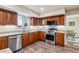 Well-lit kitchen featuring stainless steel appliances, granite countertops, and wood cabinets at 7641 Lebrun Ct, Lone Tree, CO 80124