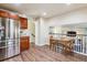 Spacious kitchen featuring stainless steel refrigerator and adjacent dining area and staircase at 7641 Lebrun Ct, Lone Tree, CO 80124