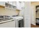 Well-organized laundry room with washer, dryer, storage shelves, and closet space at 7641 Lebrun Ct, Lone Tree, CO 80124