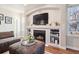 Inviting living room showcasing a fireplace, built-in shelves, and a comfortable ottoman at 7641 Lebrun Ct, Lone Tree, CO 80124