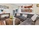 Bright living room featuring a large sofa, decorative pillows, and view to the kitchen at 7641 Lebrun Ct, Lone Tree, CO 80124