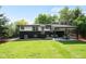 Spacious backyard featuring lush lawn, covered patio, and well-maintained landscaping at 6512 Upham St, Arvada, CO 80003