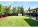 A well-maintained backyard includes a lush green lawn, mature trees, and a practical storage shed at 6512 Upham St, Arvada, CO 80003