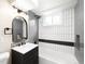 Stylishly updated bathroom featuring a shower/tub combo, sleek fixtures, and modern vertical tile accents at 6512 Upham St, Arvada, CO 80003