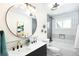 Modern bathroom with double sink vanity, decorative mirror, and tiled shower at 6512 Upham St, Arvada, CO 80003