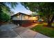 View of the home featuring clean lines, a practical driveway, and a covered front porch entry at 6512 Upham St, Arvada, CO 80003
