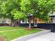 Charming home featuring mature trees, a well-manicured lawn, and an inviting front porch at 6512 Upham St, Arvada, CO 80003