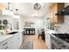 Bright kitchen featuring a large island with a gold faucet, modern appliances, and a decorative lighting fixture at 6512 Upham St, Arvada, CO 80003