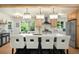Open kitchen concept with large island, stainless steel appliances, and decorative lighting fixtures at 6512 Upham St, Arvada, CO 80003