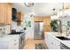 Spacious kitchen featuring an island, stainless steel appliances, custom tile, and hardwood floors at 6512 Upham St, Arvada, CO 80003