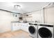 Bright basement laundry room with front loading washer/dryer and modern white cabinetry at 6512 Upham St, Arvada, CO 80003