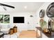 Bright living room with mounted television, tree views, a large sofa, and light wood floors at 6512 Upham St, Arvada, CO 80003
