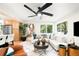 Cozy living room featuring a large fan, a white sectional, and tree views through large windows at 6512 Upham St, Arvada, CO 80003