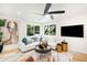 Well-lit living room with tree views, stylish decor, comfortable seating, and large television at 6512 Upham St, Arvada, CO 80003