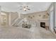 Cozy living room features a fireplace, ceiling fan, and staircase to the upper level at 1354 Carlyle Park Cir, Highlands Ranch, CO 80129