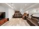 Finished basement area featuring wood laminate flooring and comfortable seating with leather couches at 4650 S Laredo St, Aurora, CO 80015