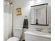Bright bathroom featuring a toilet, shower with white curtain, mirror, and sink at 4650 S Laredo St, Aurora, CO 80015