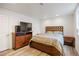 Bedroom featuring a wood frame bed and media stand with a TV and wood laminate flooring at 4650 S Laredo St, Aurora, CO 80015