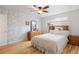 Cozy bedroom featuring hardwood floors, a ceiling fan, and a large window for natural light at 4650 S Laredo St, Aurora, CO 80015