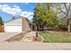 Charming home with a well-maintained front yard, mature trees, and stone pathway leading to the entrance at 4650 S Laredo St, Aurora, CO 80015