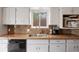 Updated kitchen featuring a stainless steel sink, mosaic backsplash, and modern appliances at 4650 S Laredo St, Aurora, CO 80015