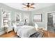 Light-filled bedroom with blue-green walls, hardwood floors, and a comfortable bed adorned with plush pillows at 2823 N Lafayette St, Denver, CO 80205