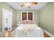 Bedroom features green walls, a ceiling fan, and a bed adorned with decorative pillows and a cozy throw at 2823 N Lafayette St, Denver, CO 80205