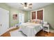 Bedroom features green walls, a ceiling fan, and a bed adorned with decorative pillows and a cozy throw at 2823 N Lafayette St, Denver, CO 80205