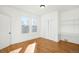 Sunlit bedroom with hardwood floors, two large windows, and built-in shelving on a white wall at 2823 N Lafayette St, Denver, CO 80205