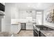 Bright kitchen showcases white cabinetry, a farmhouse sink, stainless steel appliances, and gas cooktop island at 2823 N Lafayette St, Denver, CO 80205