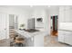 Bright kitchen with white cabinetry, stainless appliances, a gas cooktop island, and adjacent stairs at 2823 N Lafayette St, Denver, CO 80205