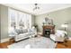 Sunlit living room with hardwood floors, fireplace, and a large window offering a serene view at 2823 N Lafayette St, Denver, CO 80205