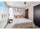 Light-filled bedroom with a bed, side table, large window, and minimalist decor at 1287 Quitman St, Denver, CO 80204