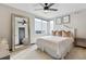Bright bedroom features a large mirror, ceiling fan, bed with plush pillows and minimalist decor at 1287 Quitman St, Denver, CO 80204