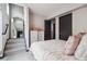 Bright bedroom with a cozy bed, adjacent to stairway, a decorative mirror, and closet space at 1287 Quitman St, Denver, CO 80204