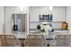 Close-up of modern kitchen island, stainless steel appliances, neutral cabinetry and stylish pendant lights at 1287 Quitman St, Denver, CO 80204