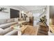 Open-concept living room with hardwood floors, modern furniture and a view of the kitchen and staircase at 1287 Quitman St, Denver, CO 80204