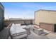 Inviting rooftop deck area with comfortable lounge seating, rocking chairs, and a modern fire pit feature at 1287 Quitman St, Denver, CO 80204