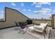 Relaxing rooftop deck featuring lounge furniture, rocking chairs, grill, and expansive city views at 1287 Quitman St, Denver, CO 80204
